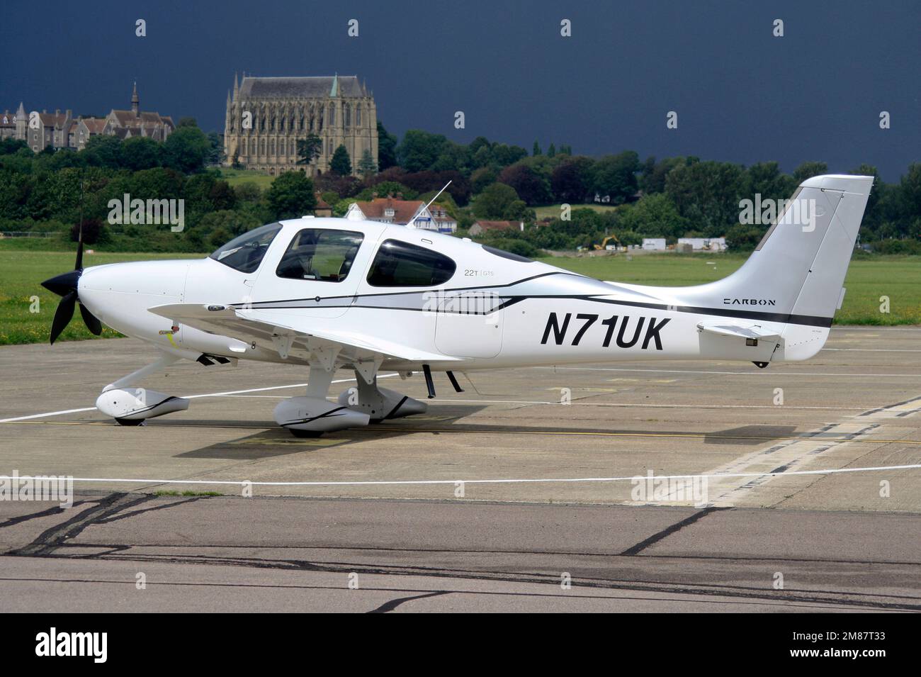 Un Cirrus SR22T-GTS G5 Carbon sur la rampe de l'aéroport de Brighton City avec Lancing Collega et ciel orageux à l'arrière Banque D'Images