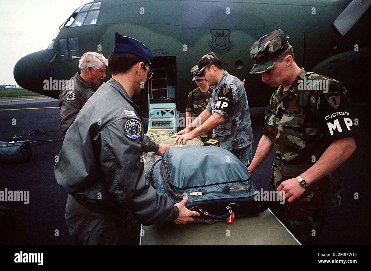 Les inspecteurs des douanes de l'Armée de terre vérifient les bagages des membres de l'escadre du transport aérien tactique de 440th, Réserve de la Force aérienne, avant leur départ par un avion C-130A Hercules. Les réservistes, qui reviennent aux États-Unis pendant la phase de redéploiement de l'exercice Volant Partner 87-1, ont effectué des missions de transport aérien dans 30 bases aériennes de neuf pays de l'OTAN au cours de leur déploiement en Europe. Objet opération/série: VOLANT PARTNER 87-1 base: Base aérienne de Chievres État: Hainaut pays: Belgique (bel) Banque D'Images