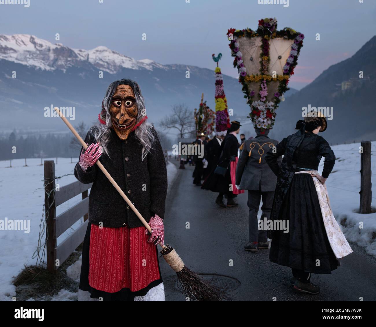 AUTRICHE, GASTEIN - 1 janvier 2023: Sorcière avec un balai et danse perchten sur fond de montagnes Banque D'Images