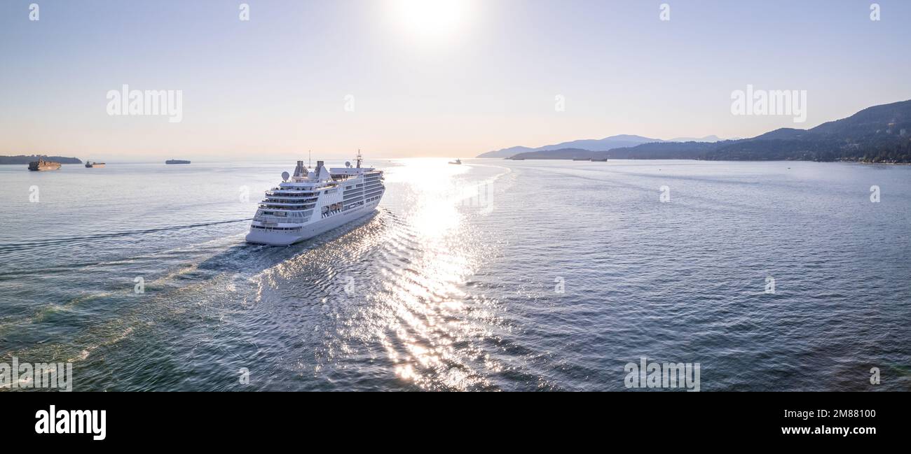 Bateau de croisière naviguant hors du port de Vancouver au coucher du soleil, ligne de croisière, grand bateau, croisière de luxe, images aériennes. Banque D'Images