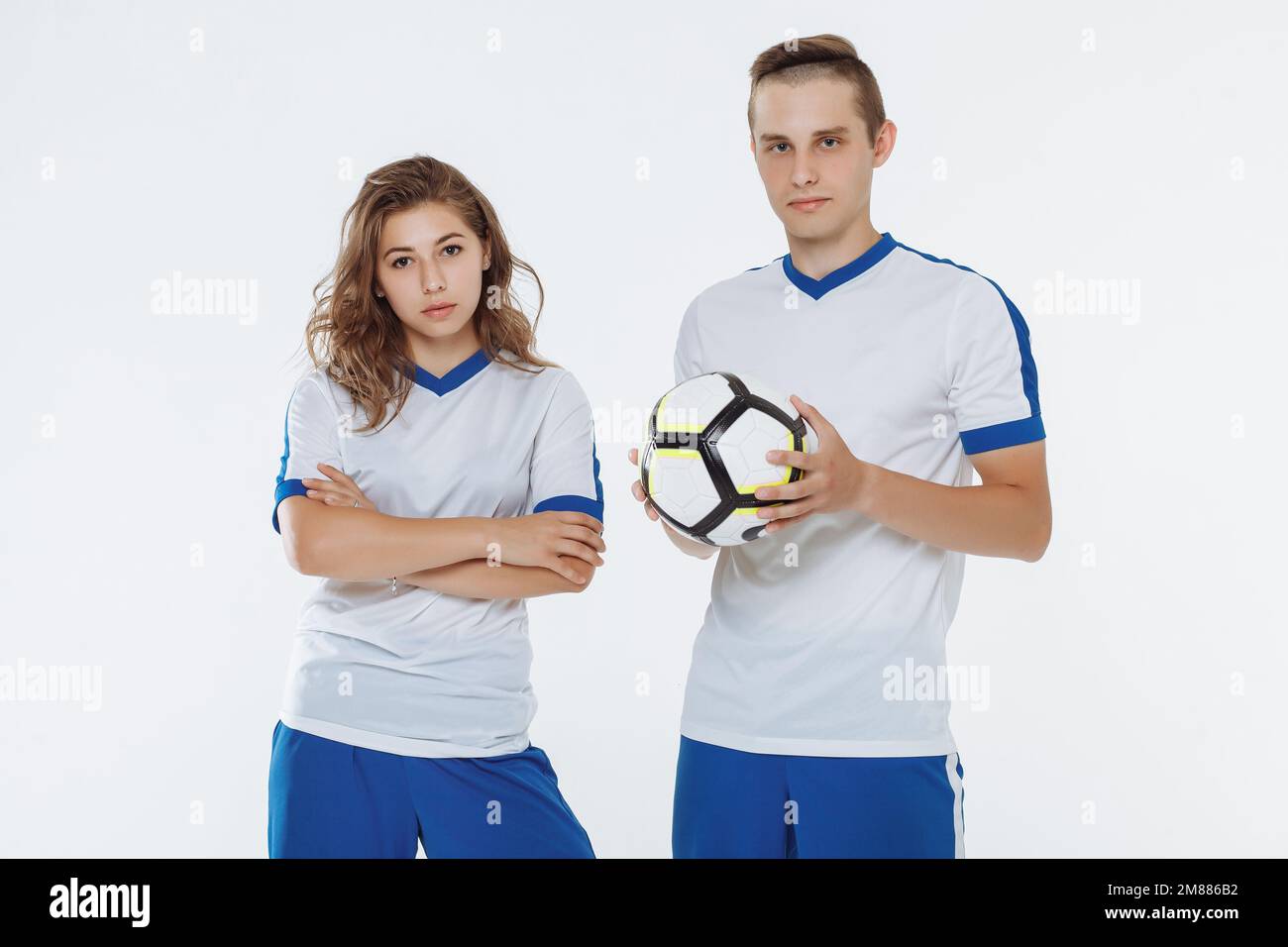 Joueur de football et une fille de football en uniforme blanc avec une balle isolée Banque D'Images