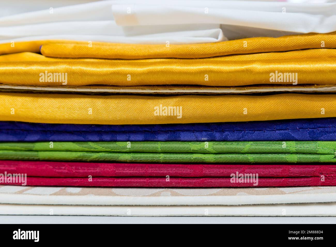 Une pile de burses, de salopettes, de voiles et de tissus aux couleurs liturgiques utilisées pour la sainte communion dans les églises Banque D'Images