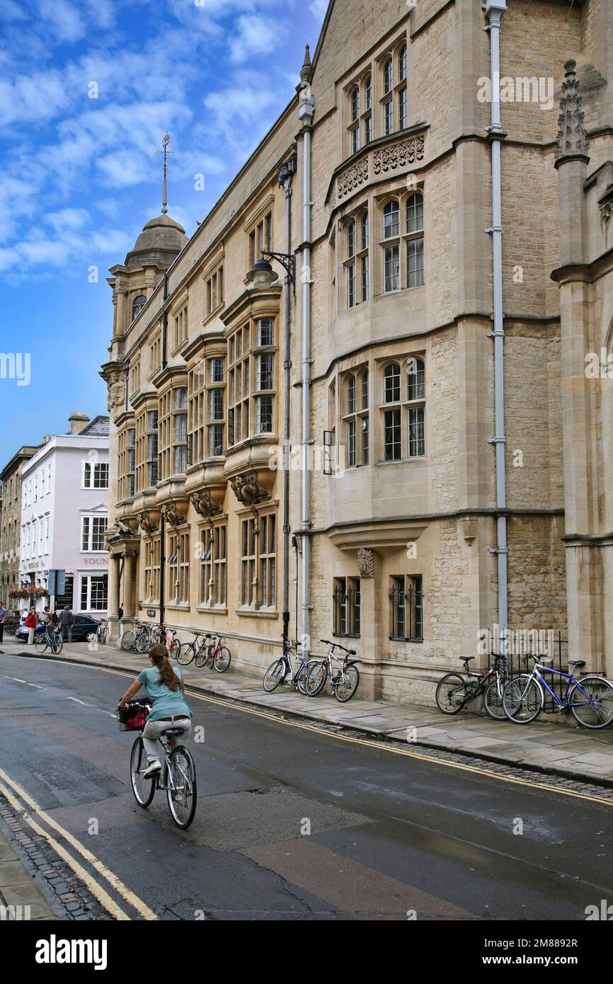 Rue avec le bâtiment de l'Université d'Oxford et pub, et cycliste sur la route Banque D'Images