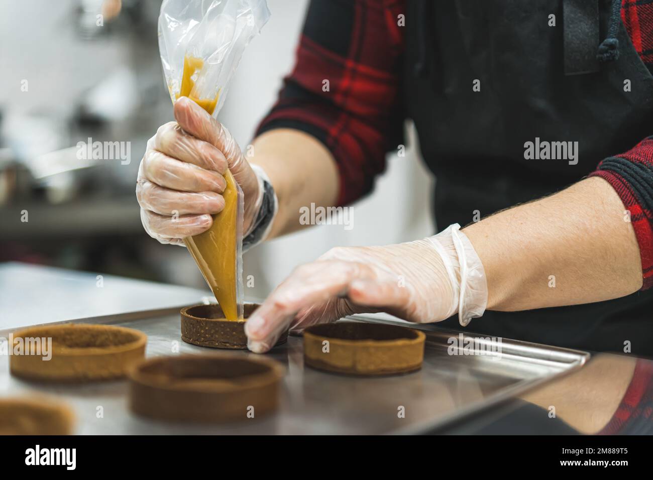 baker piping caramel en forme de cercle sur un plateau, processus de décodage des biscuits. Photo de haute qualité Banque D'Images