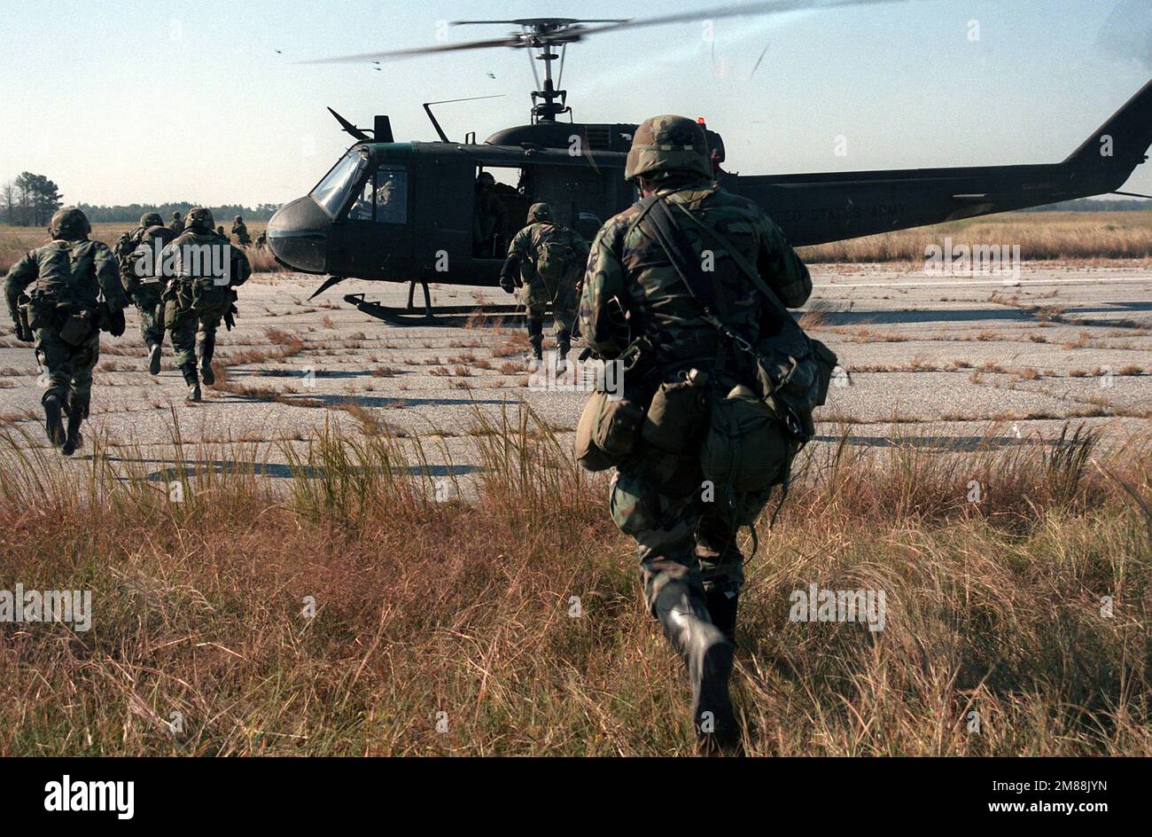 Soldats de Co. C, 1st BN., 505th parachute Infantry Regt., courir vers un hélicoptère UH-1 Iroquois en attente lors d'un exercice conjoint de la Force aérienne et de l'Armée de terre en chute libre/assaut aérien. Base : aéroport du comté de Darlington État : Caroline du Sud (SC) pays : États-Unis d'Amérique (USA) Banque D'Images
