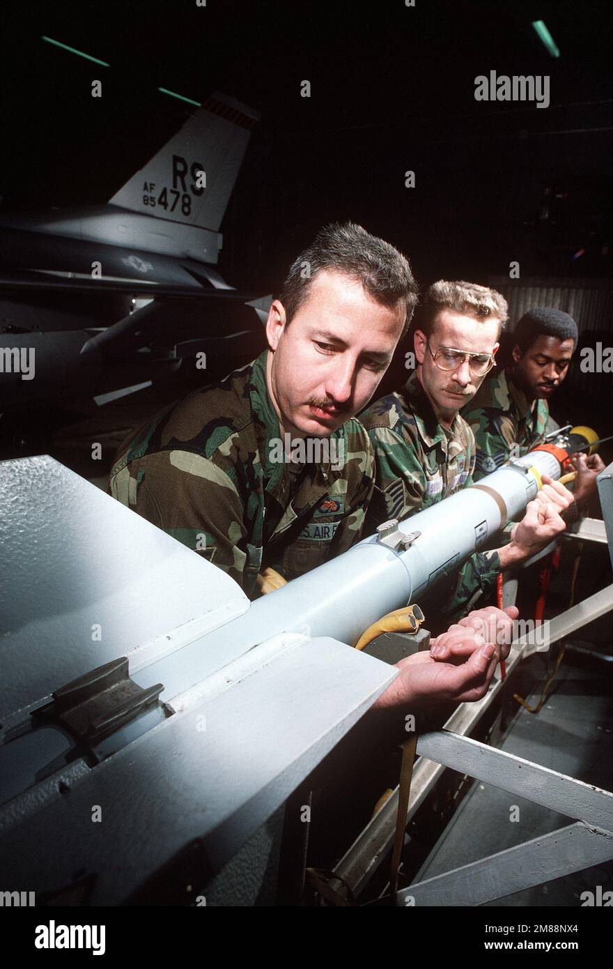 SSGT Paul Taylor, à gauche, TSGT Kirk Shirar, au centre, et SSGT Leegusta Moore, techniciens en armement de l'Escadron de génération d'aéronefs 86th, se préparent à lever un missile SIDEWINDER AIM-9 avant du charger à bord d'un avion faucon de combat F-16C de la Fighter tactique 86th. Base: Ramstein Air base État: Rheinland-Pfalz pays: Allemagne (DEU) Banque D'Images