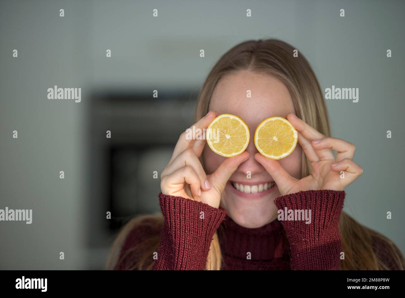 Jeune femme, couper des fruits, se moquer dans la cuisine, s'amuser avec les citrons, haute-Bavière, Bavière, Allemagne, Europe Banque D'Images