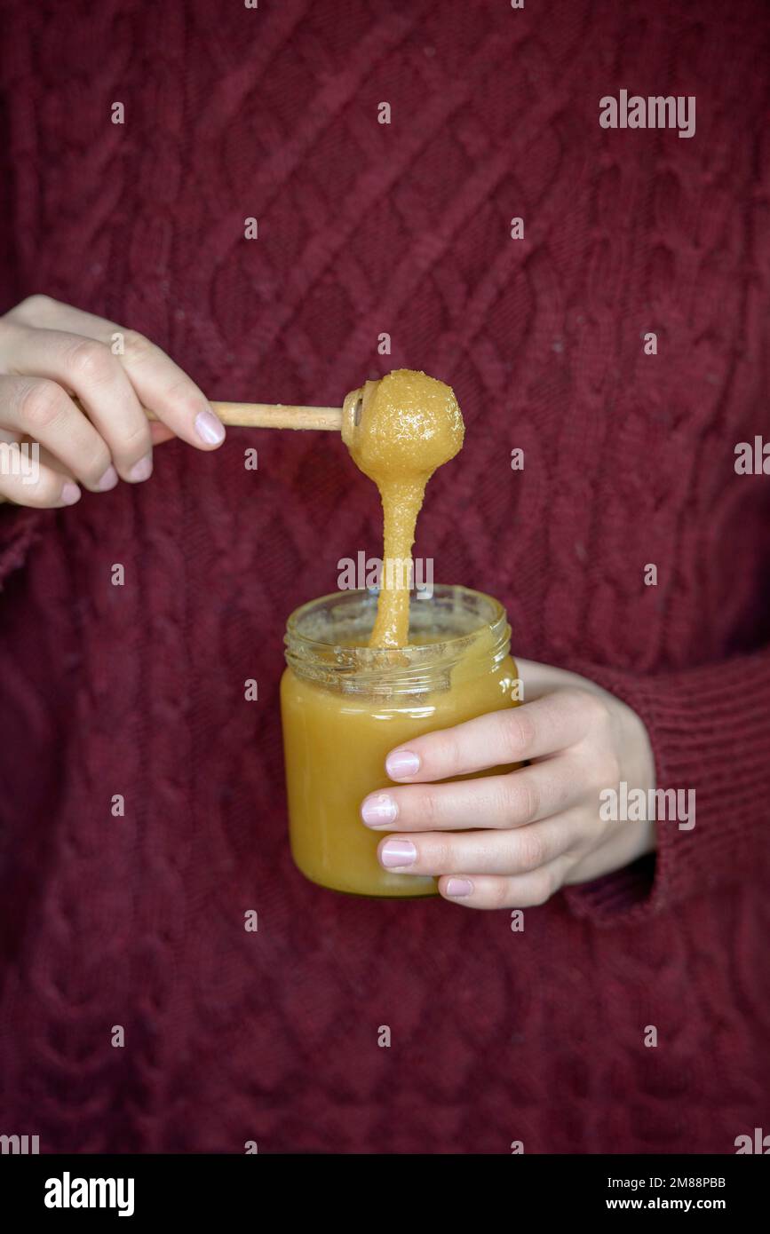 Mains tenant un pot de miel avec une cuillère à miel, haute-Bavière, Bavière, Allemagne, Europe Banque D'Images