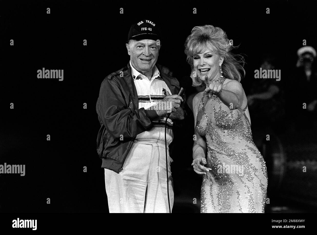 Le comédien Bob Hope et l'animateur Barbara Eden divertissent les membres de l'équipage du navire d'assaut amphibie USS OKINAWA (LPH-3) lors d'un spectacle de Noël de l'Organisation des services Unis pour les marins qui patrouillent le golfe. Le navire est ancré au large de la côte de Bahreïn. Pays : inconnu Banque D'Images