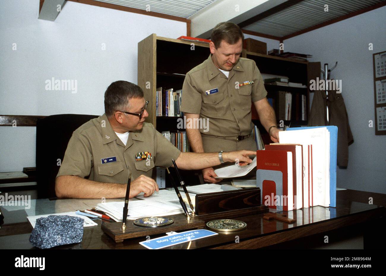 Le capitaine Howe, assis, et le lieutenant J.G. Snowdon, les deux aumôniers servant à bord de la station aérienne, élabore des plans pour un événement de collecte de fonds. Base: Naval Air Station, Sigonella État: Sicile pays: Italie (ITA) Banque D'Images