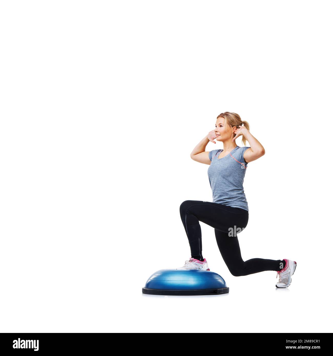 Elle suit un plan de forme physique strict. Une jeune femme attirante lapira ses cuisses sur un bosu-ball. Banque D'Images