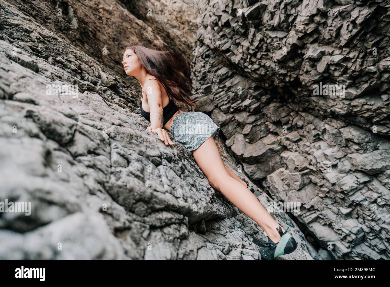 Femme sportive grimpant sur le rocher. Jeune femme avec corps ajusté c Banque D'Images