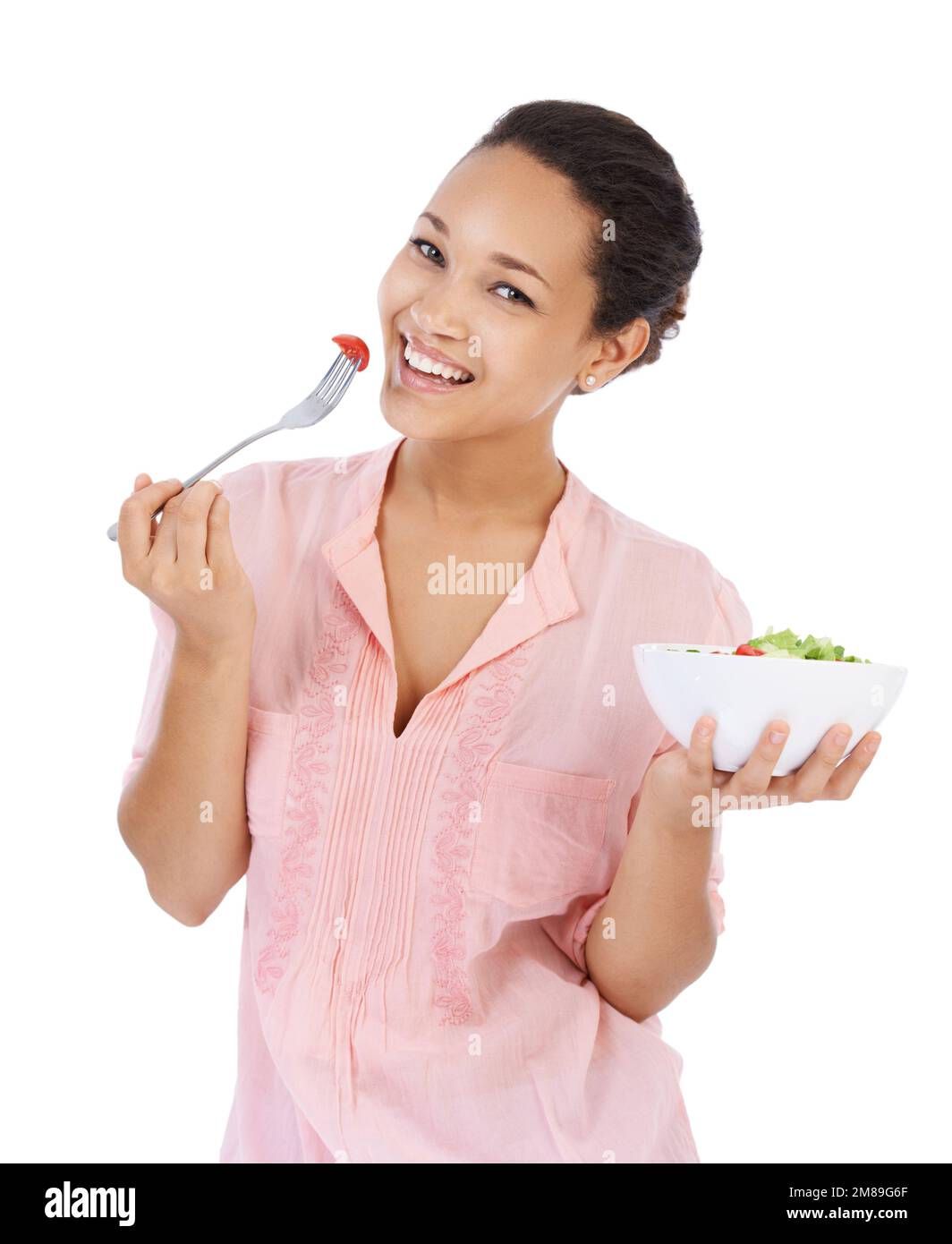 MMM, cette salade est si savoureuse. Jeune femme souriant tout en mangeant une salade verte fraîche. Banque D'Images