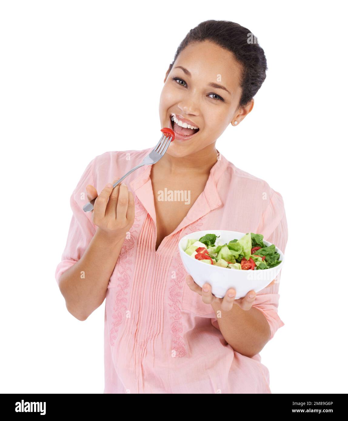 Un repas délicieux et sain. Jeune femme souriant tout en mangeant une salade verte fraîche. Banque D'Images