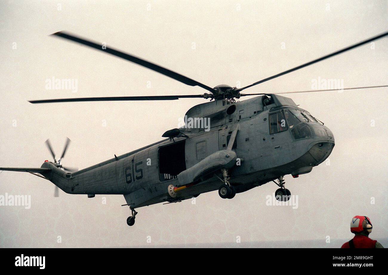 Vue du côté droit d'un hélicoptère SH-3H Sea King de l'escadron 5 (HS-5) hélicoptère anti-sous-marin survolant le pont de vol du porte-avions à propulsion nucléaire USS DWIGHT D. EISENHOWER (CVN-69). Pays: Mer méditerranée (MED) Banque D'Images