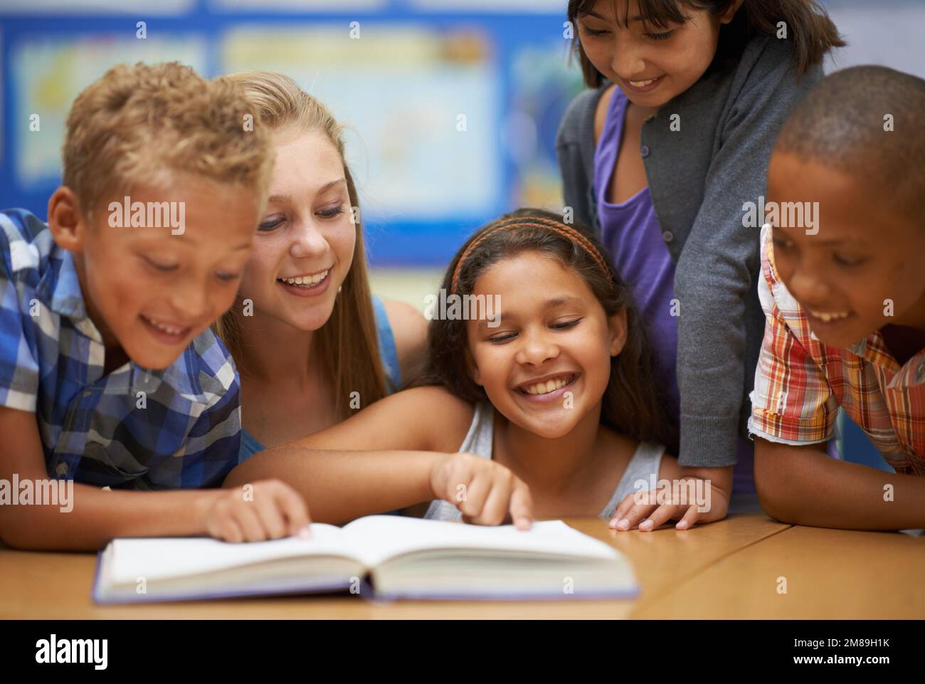 Lecture en groupe en classe anglaise. Un groupe d'élèves lisant un livre pendant la classe. Banque D'Images