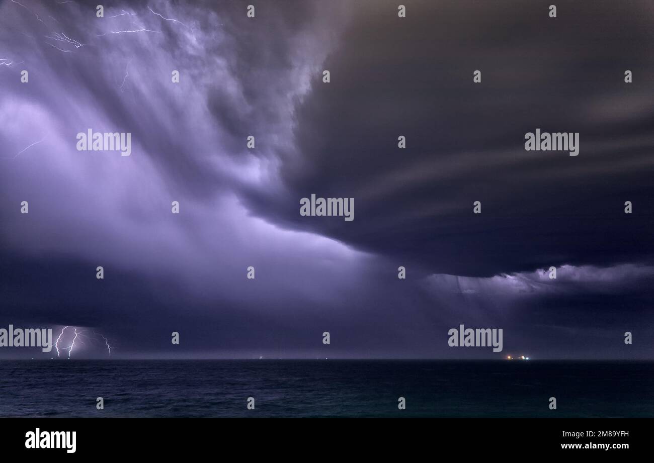 Orage avec foudre la nuit au-dessus de l'océan Banque D'Images