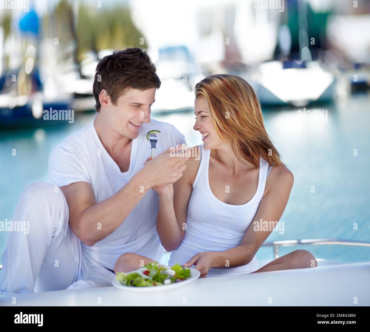 Ils aiment la nourriture saine. Jeune couple appréciant une salade fraîche ensemble. Banque D'Images