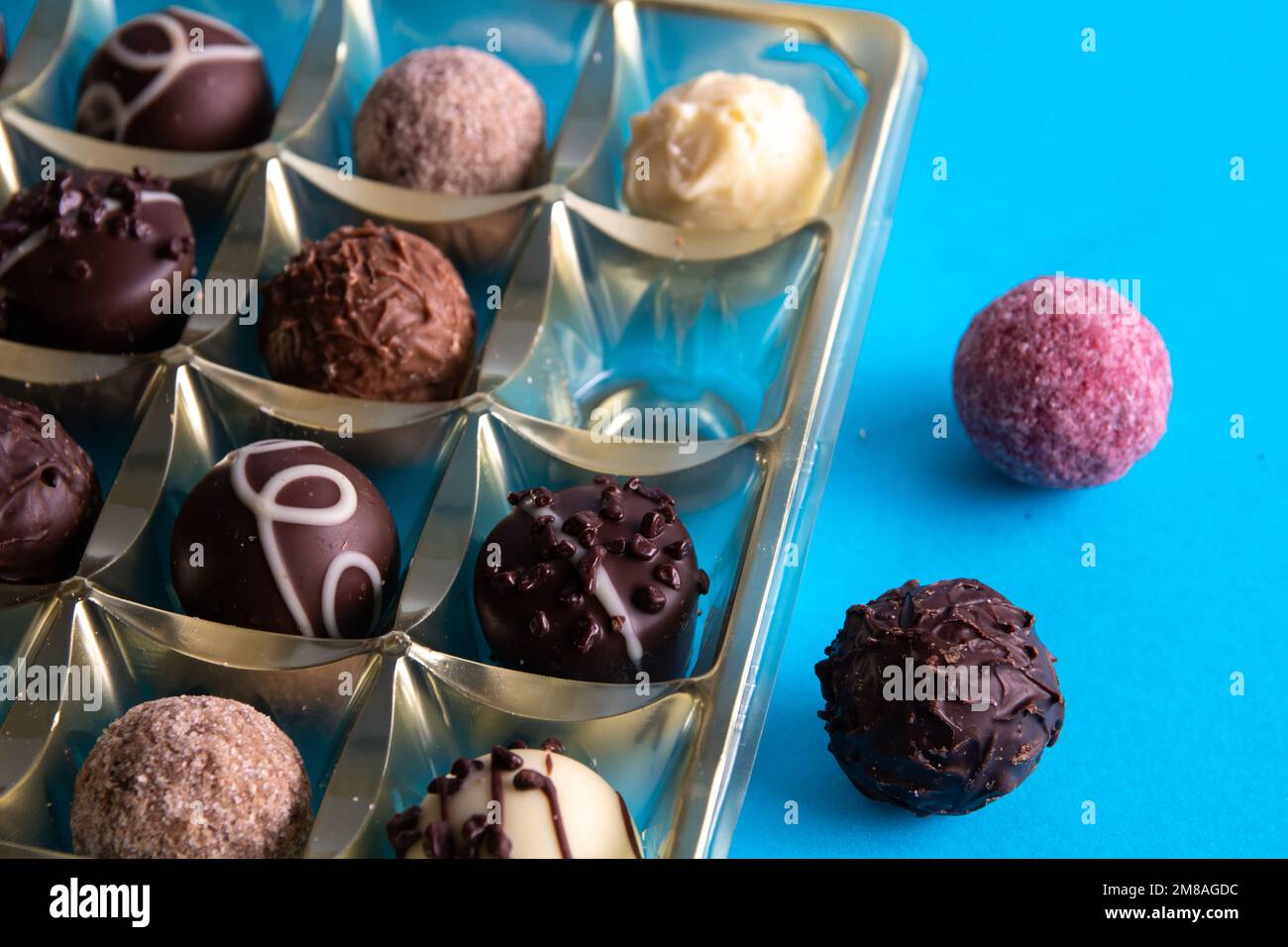 photo de chocolats dans une boîte sur fond bleu Banque D'Images