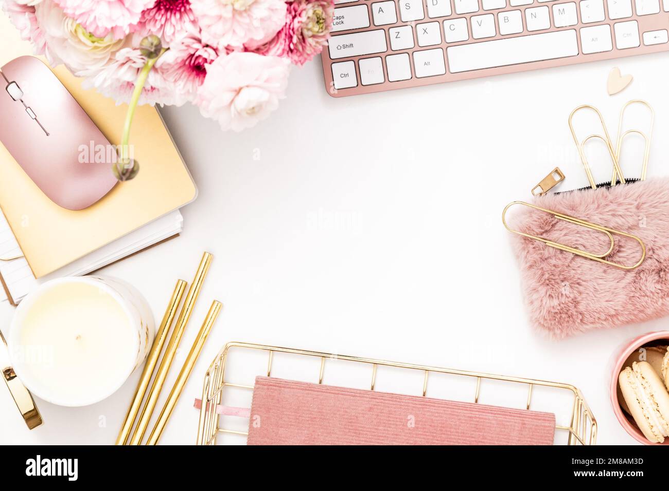 Bureau féminin avec papeterie or et rose comprenant un clavier et une souris Banque D'Images