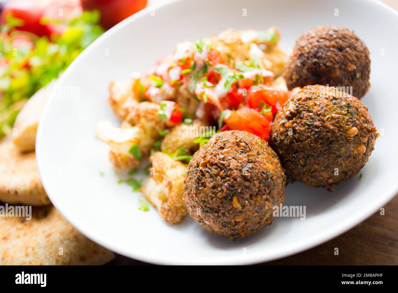 Plat combiné de falafel avec légumes. Faláfel ou falafel​ est une croquette de pois chiches ou de fèves. Il est généralement consommé au Moyen-Orient. Banque D'Images