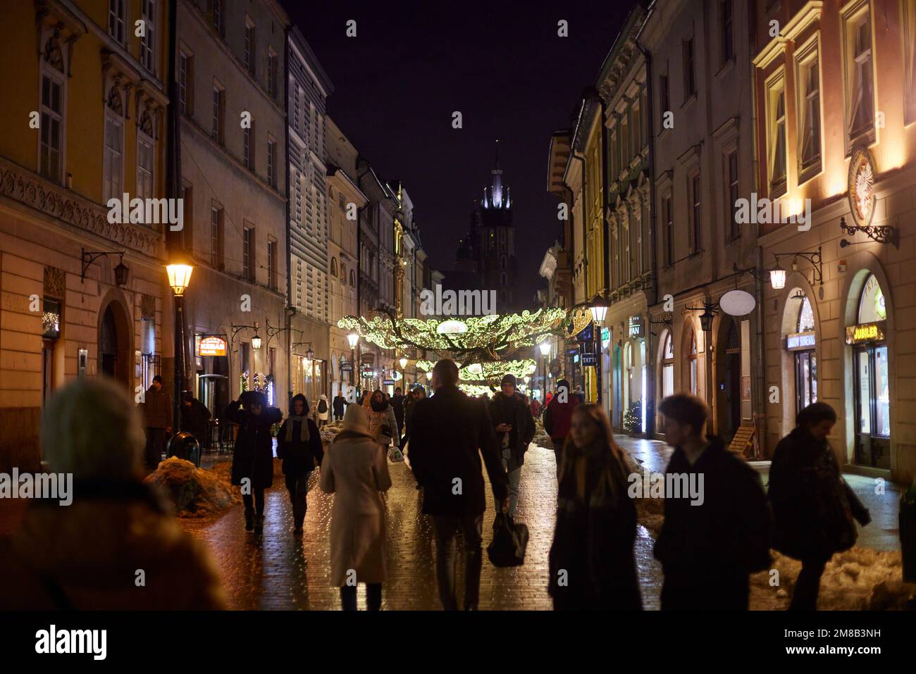 Marche nocturne le long de la rue Florianska à Cracovie, en Pologne. Nous voyons la décoration de Noël de la rue. Banque D'Images