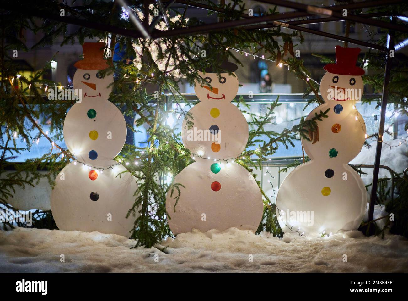 Trois bonhommes de neige dans la rue en hiver se tiennent sous forme de décorations pour photographies. Banque D'Images