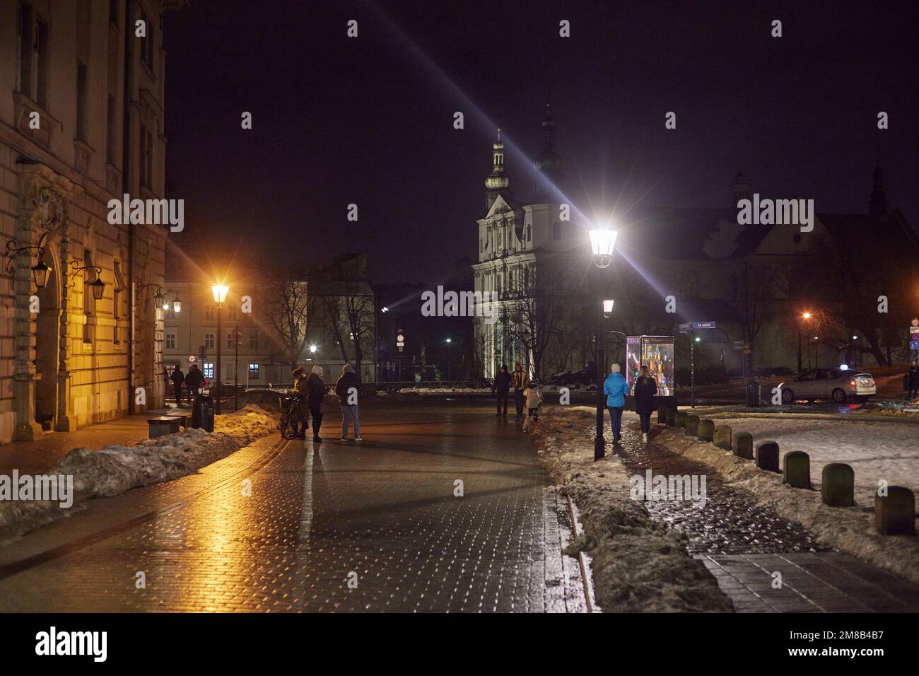 Rue de Cracovie et église de Saint Bernardine de Sienne avec des personnes marchant la nuit. Banque D'Images