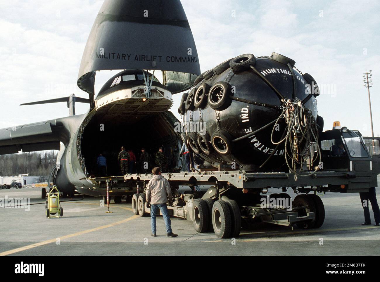 Les membres de l'escadron du port aérien 616th déchargent de l'équipement d'un aéronef Galaxy C-5B de l'escadron du transport aérien militaire 3rd sur un chargeur K. L'équipement sera utilisé pour le nettoyage de l'huile déversée par le pétrolier Exxon Valdez dans Price William Sound. Base: Elmendorf Air Force base État: Alaska (AK) pays: Etats-Unis d'Amérique (USA) Banque D'Images