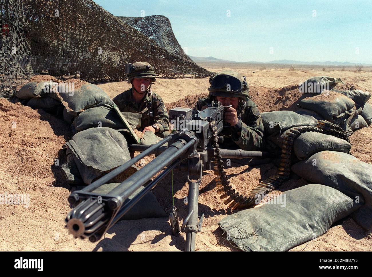 Un soldat se présente avec une mitrailleuse de calibre .50 lors d'un exercice au Centre national d'entraînement. Le canon est équipé d'un dispositif de tir à blanc et de plusieurs engrenages du système d'engagement laser intégré (MILES). Base: Fort Irwin État: Californie (CA) pays: États-Unis d'Amérique (USA) Banque D'Images