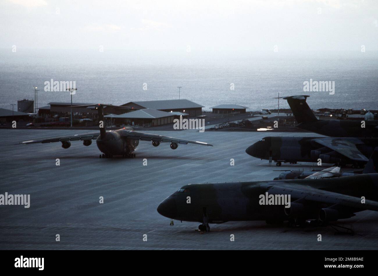 Un service de transport aérien militaire C-5B Galaxy Aircraft taxis sur le terrain comme autre C-5BS ligne le champ. L'avion s'arrête sur l'île après le transport des troupes finlandaises des Nations Unies en Namibie pour servir de force de maintien de la paix. Pays: Île de l'Ascension Banque D'Images