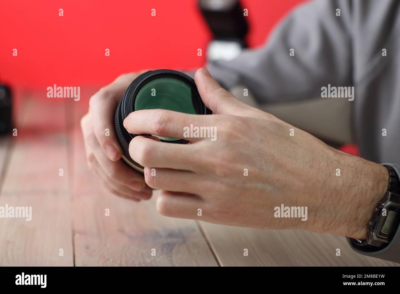 retirer le filtre de la macro-lentille sur la table par une personne sur un arrière-plan coloré Banque D'Images