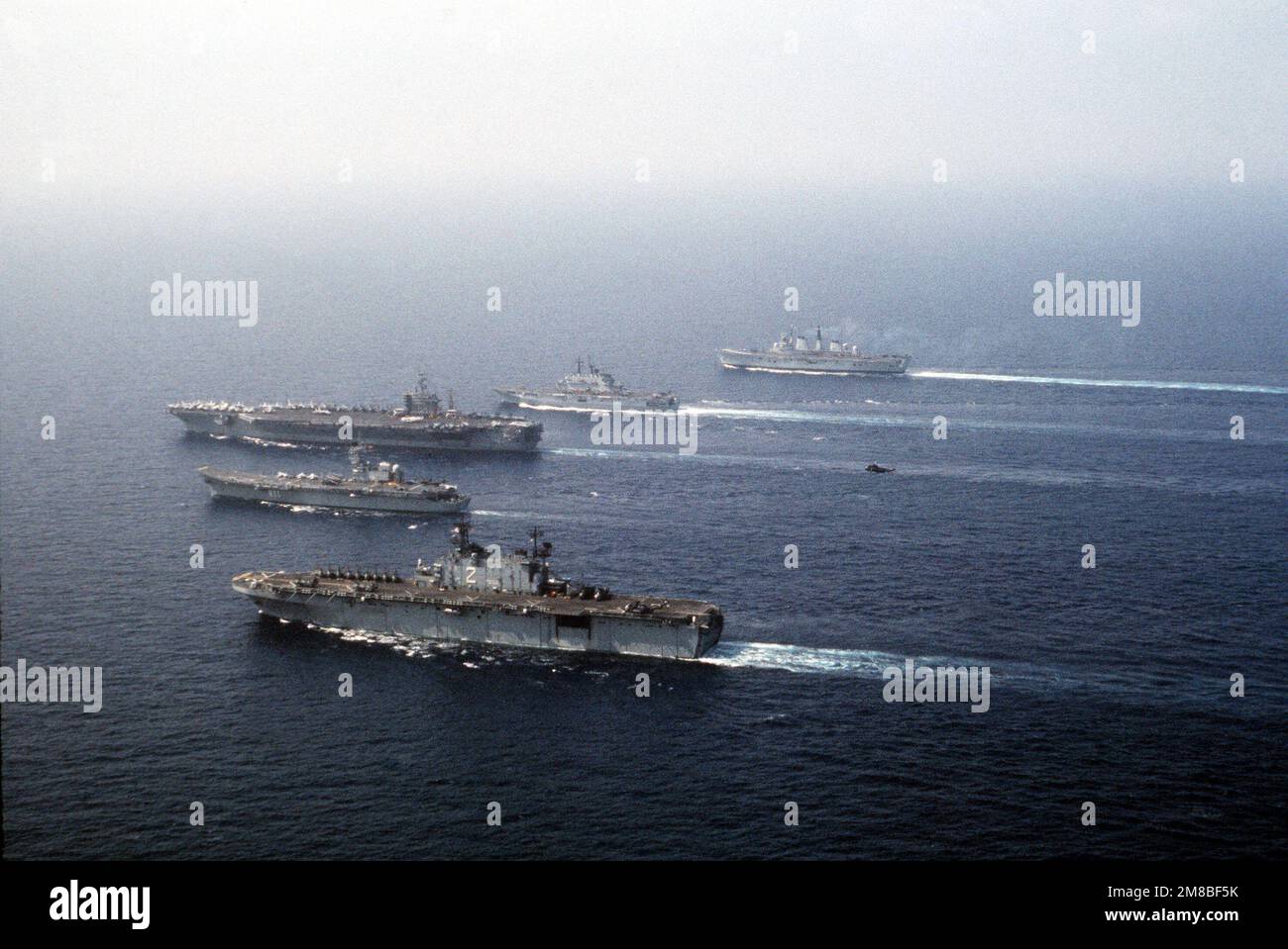 Des navires de quatre nations naviguent en formation pendant l'exercice DRAGON HAMMER '90 de la région du Sud de l'OTAN. Les navires sont, de l'avant : le navire d'assaut amphibie USS SAIPAN (LHA 2), le porte-avions espagnol SPS PRINCIPE DE ASTURIAS (R-11), le porte-avions à propulsion nucléaire USS DWIGHT D. EISENHOWER (CVN 69), le porte-avions léger italien GIUSEPPE GARIBALDI (C-551) et le porte-avions léger britannique (HMS R-05). Objet opération/série: DRAGON HAMMER '90 pays: Mer Méditerranée (MED) Banque D'Images