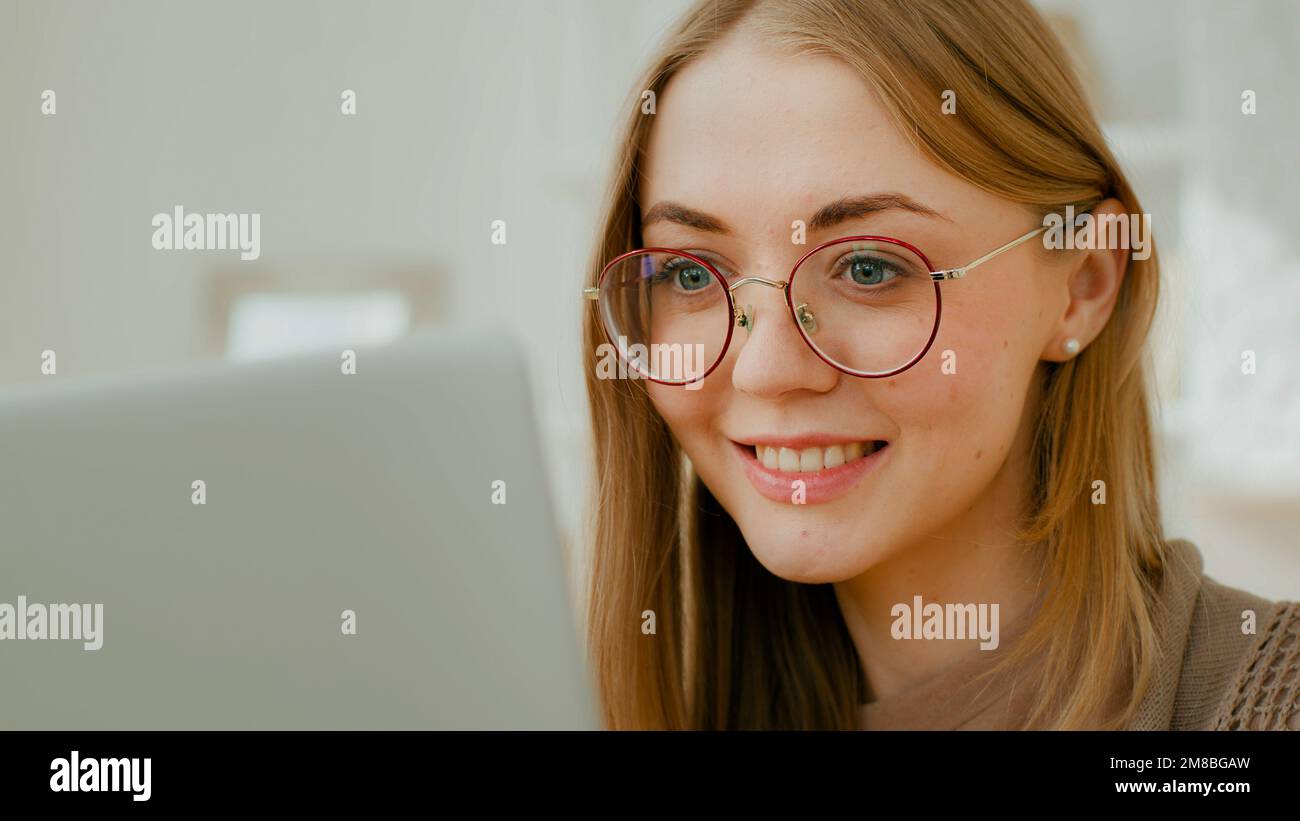 Gros plan Femme caucasienne visage fille dans des lunettes yeux regarder l'écran d'ordinateur portable. Travailleur indépendant souriant occupé par le travail informatique étudiant mal Banque D'Images