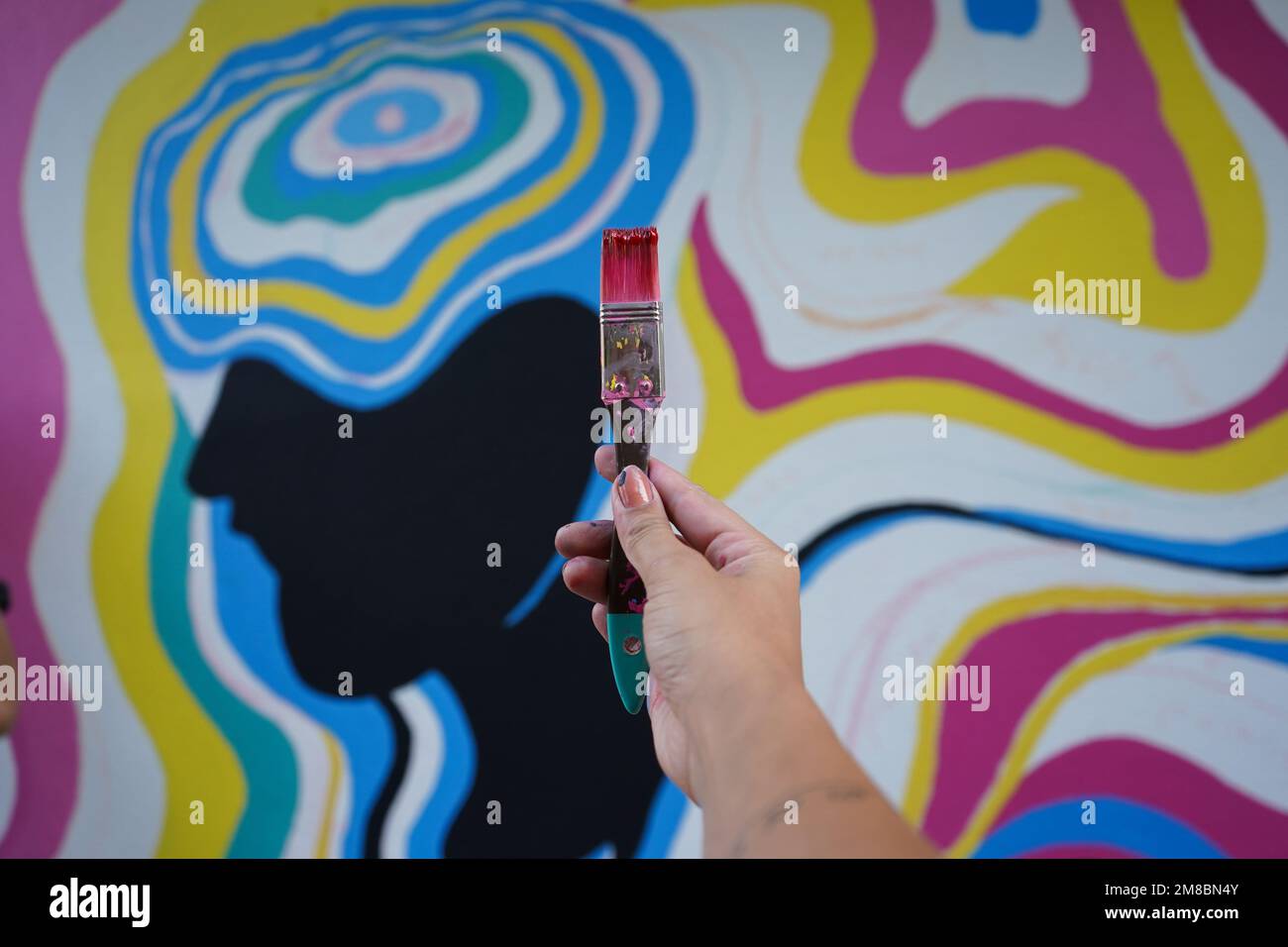 Peinture murale, belle femme peignant le mur coloré Banque D'Images