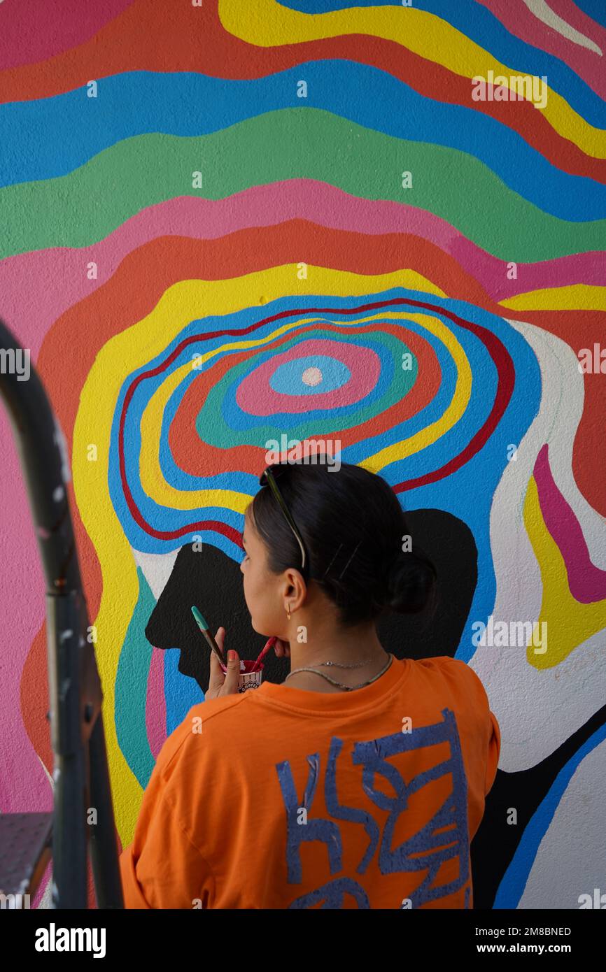 Peinture murale, belle femme peignant le mur coloré Banque D'Images