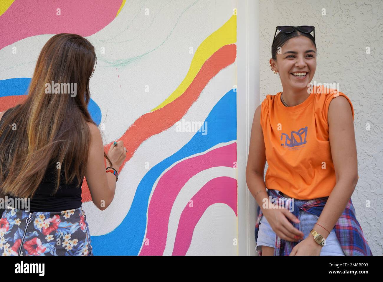 Peinture murale, belle femme peignant le mur coloré Banque D'Images