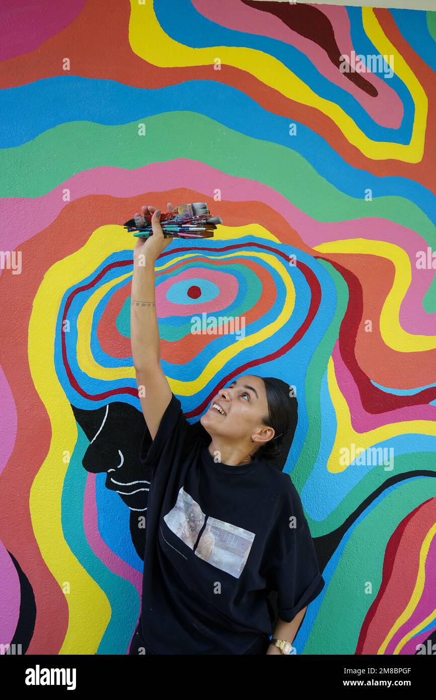 Peinture murale, belle femme peignant le mur coloré Banque D'Images