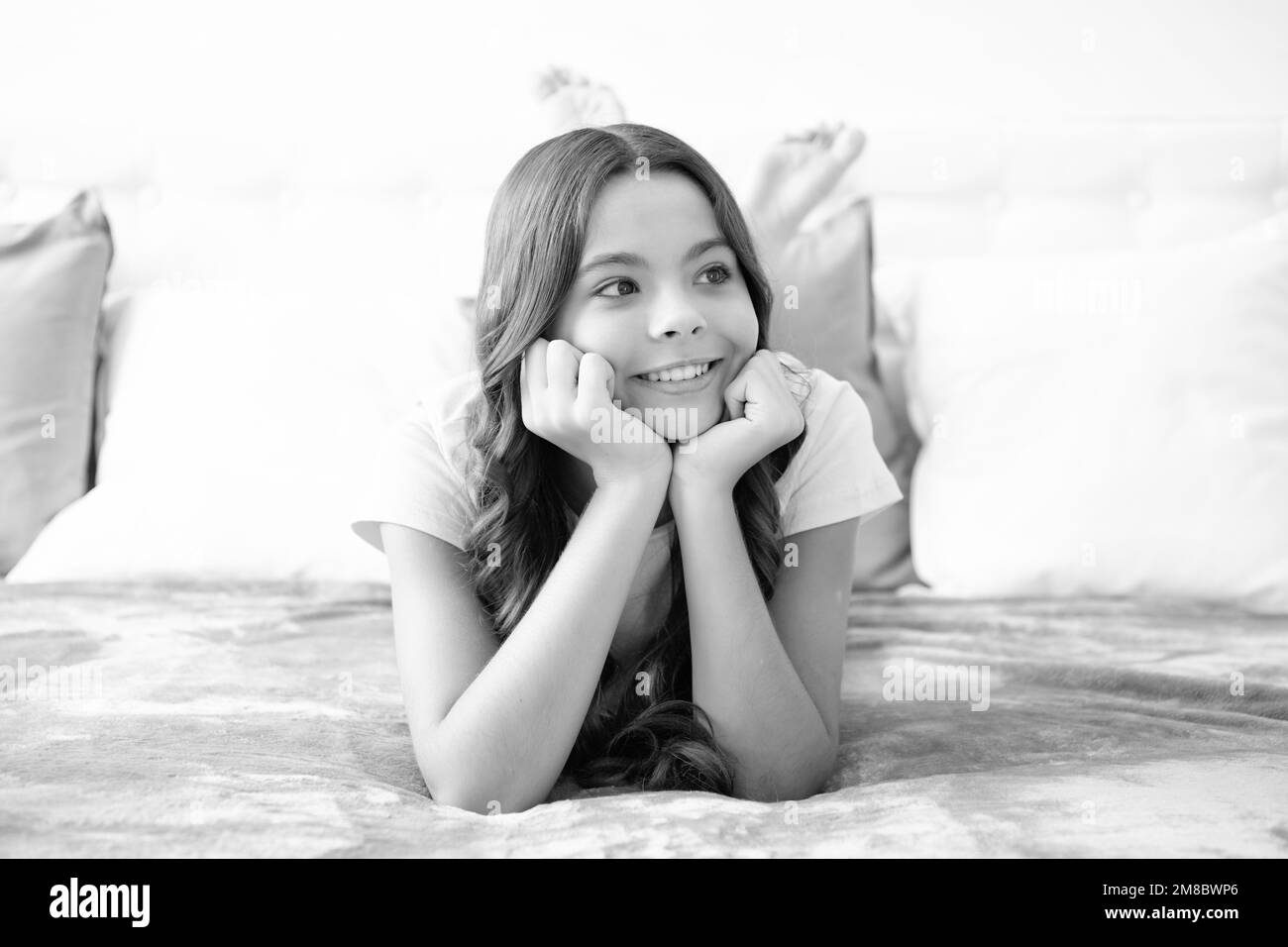 Enfant rêvant, rêvant. Adolescent fille de repos dans le lit à la chambre à la maison. Enfant se détendant à l'intérieur de la chambre. Banque D'Images