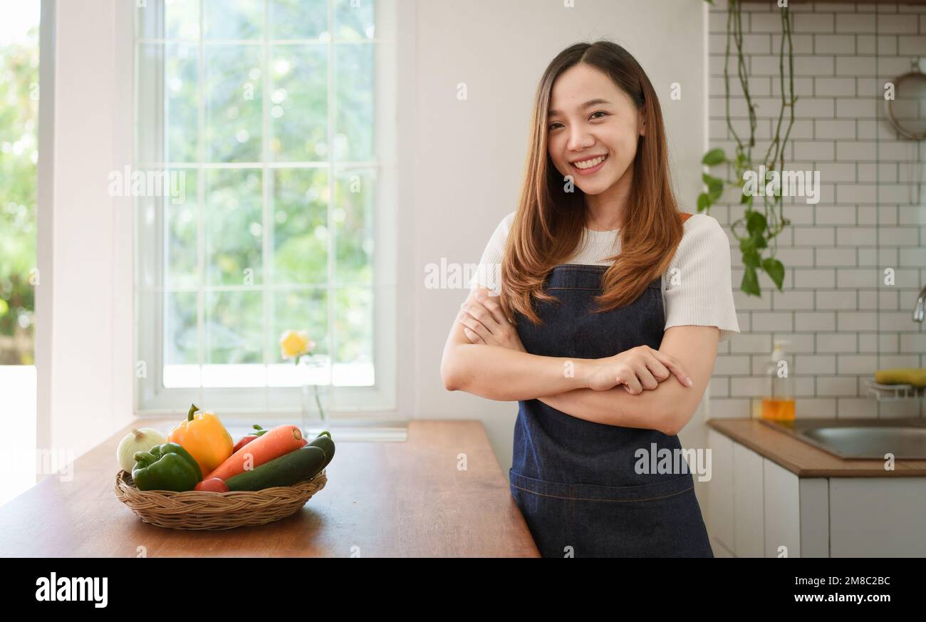 Portrait de la belle jeune femme asiatique faisant de la salade à la maison. Cuisiner des aliments et vivre des moments Banque D'Images