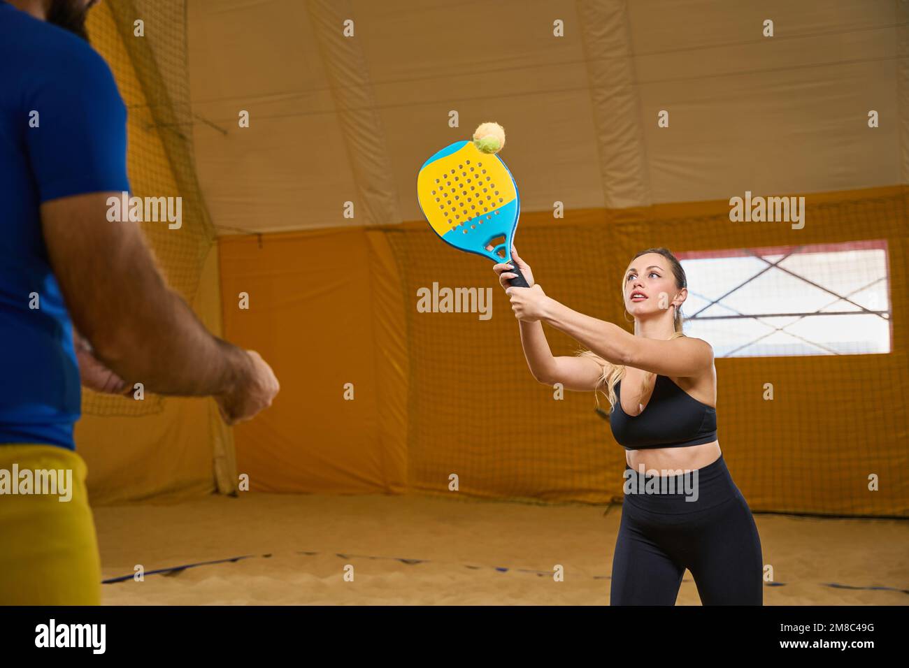 Femme avec une raquette de tennis frapper le ballon sur le terrain de jeu à  l'intérieur Photo Stock - Alamy