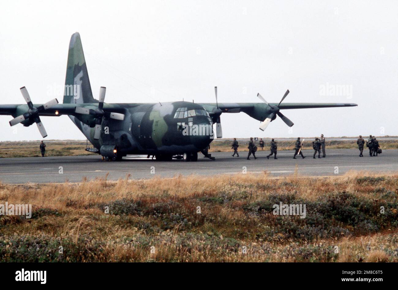 Membres de Co C, 2nd BN., 297th Infantry Group (Scout), Garde nationale de l'Alaska, débarquer d'un avion C-130 Hercules de la Force aérienne après être arrivé pour participer à l'exercice Kernal Potlatch '89. Sujet opération/série: KERNAL POTLATCH '89 base: Amchitka Island État: Alaska (AK) pays: États-Unis d'Amérique (USA) Banque D'Images