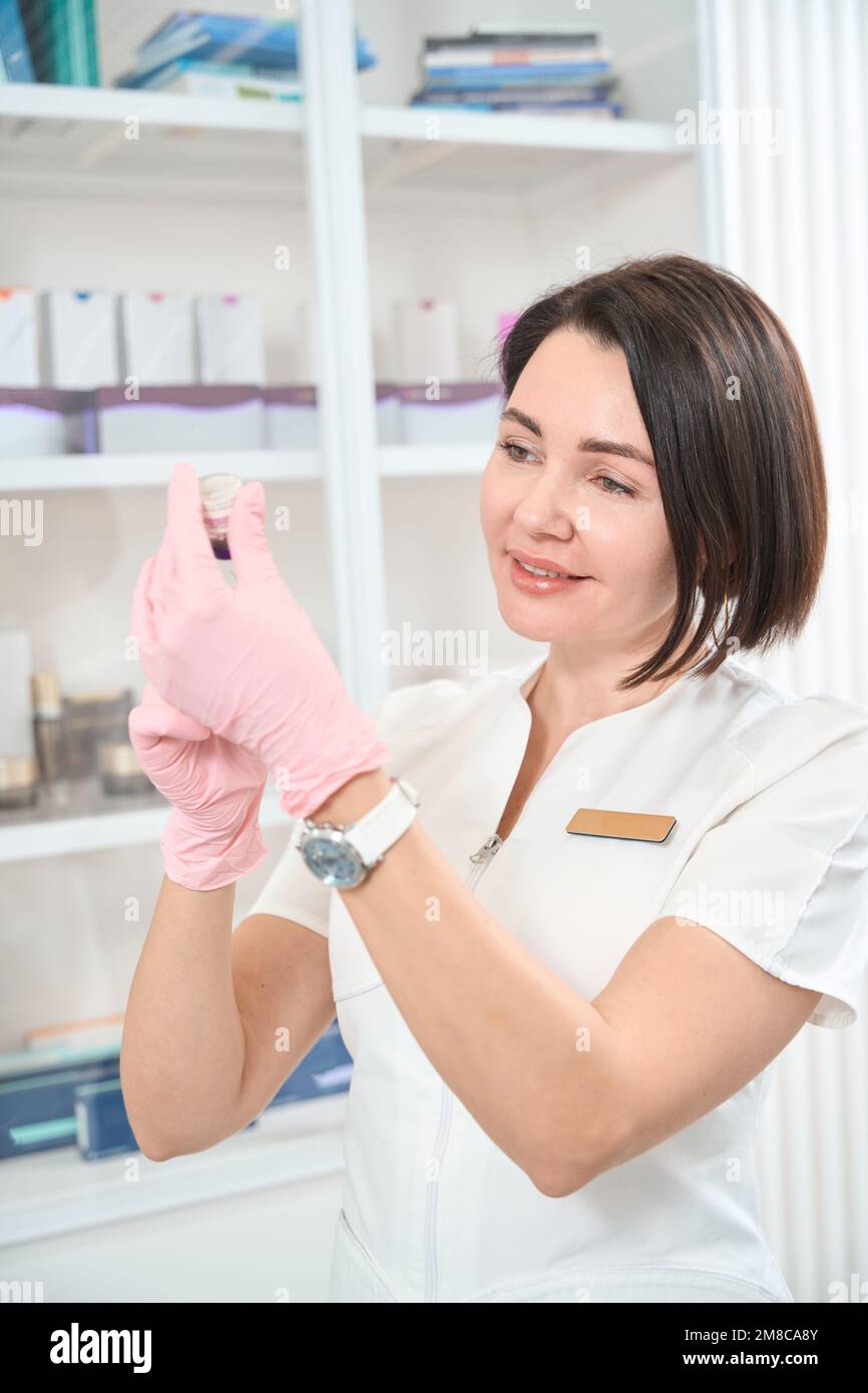 Belle femme esthéticienne dessine la médecine dans une seringue Banque D'Images