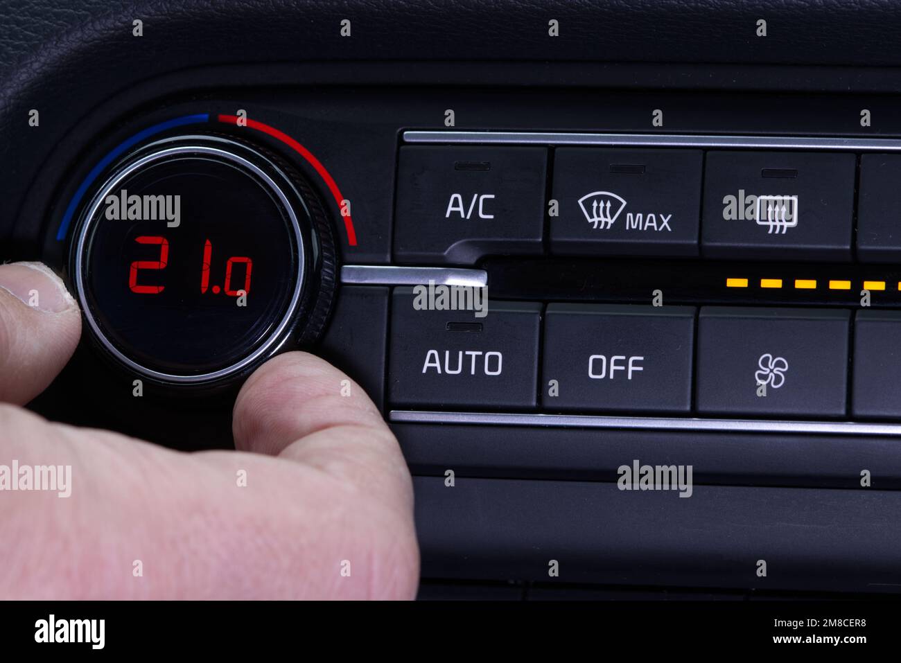 Configurez le climatiseur dans la voiture. La main fait tourner la bague du climatiseur. L'affichage indique une température de 21,0 degrés celsius à l'intérieur de la voiture. Air de refroidissement en t Banque D'Images