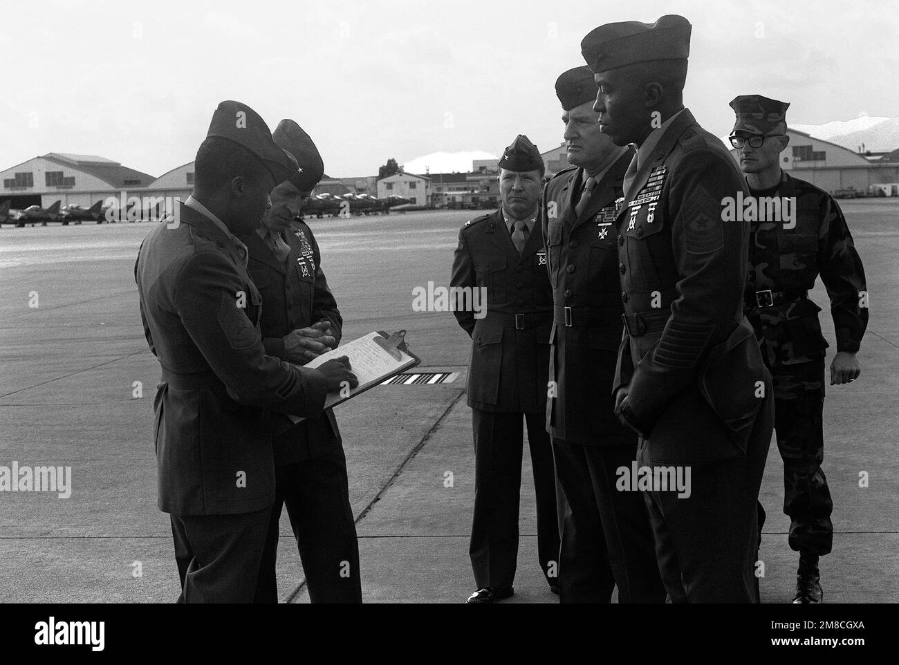 BGÉN Robert B. Johnston, deuxième à partir de la gauche, CHEF D'ÉTAT-MAJOR, bases du corps des Marines, Japon, Examine les notes d'inspection DE GUNNERY SGT Hood à la suite de la partie forage de l'inspection du commandant général de la station aérienne. En attendant les résultats sont, de droite, 1LT R.G. Durko, commandant du peloton de forage, SGM Crouch, col Robert R. Renier, commandant de la Station aérienne, et col Cruse. Base: Marine corps Air Station, Iwakuni pays: Japon (JPN) Banque D'Images