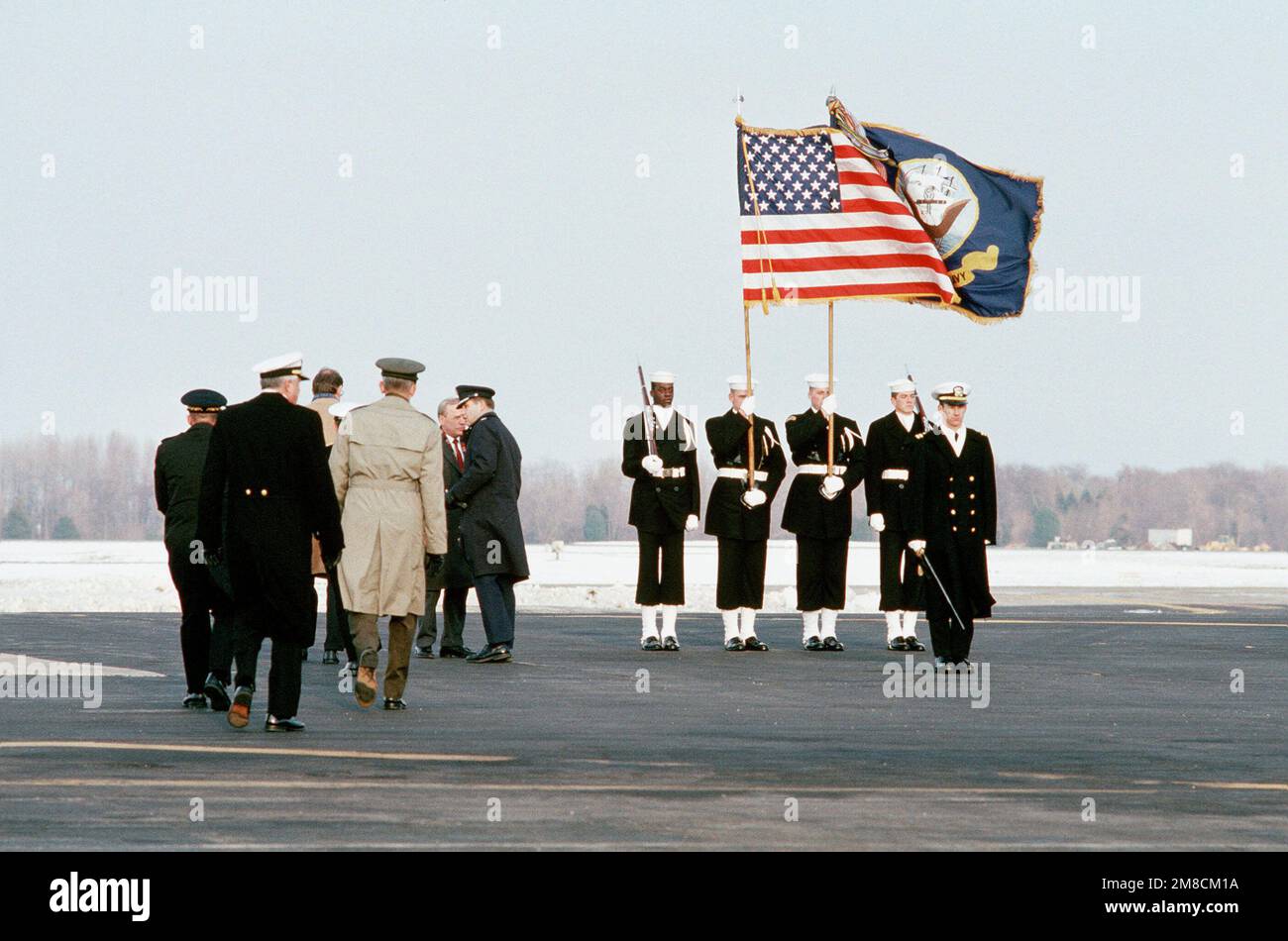 Des officiers et des dignitaires civils se réunissent à côté d'un garde-couleurs de la Marine, en attendant l'arrivée d'un avion portant les corps de quatre militaires tués dans la phase initiale de l'action militaire américaine au Panama. Les quatre militaires étaient membres d'une équipe DE PHOQUES (mer-air-terre) qui s'est assurée de l'aérodrome de Patilla en début de matinée de 20 décembre. Base: Dover Air Force base État: Delaware (DE) pays: Etats-Unis d'Amérique (USA) Banque D'Images