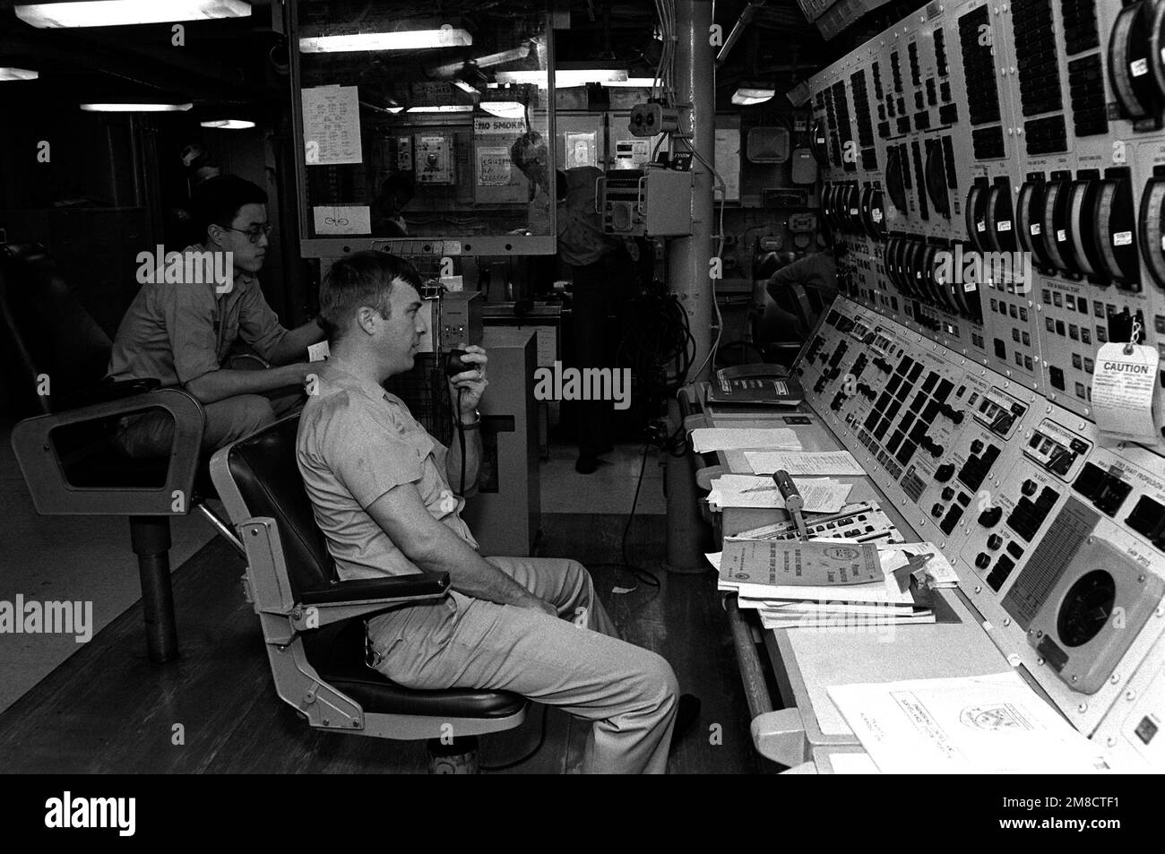 Les membres de l'équipage travaillent aux panneaux de commande du moteur dans la station de commande centrale à bord du destroyer USS PETERSON (DD 969) pendant LA FLOTTE EX 1-90. Objet opération/série: FLEET EX 1-90 base: USS Peterson (DD-969) pays: Océan Atlantique (AOC) Banque D'Images