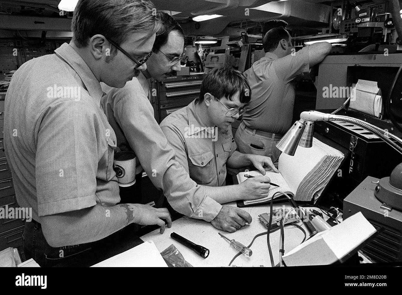 Les membres de l'équipage consultent un registre du service de maintenance intermédiaire de l'aéronef à bord du porte-avions USS JOHN F. KENNEDY (CV-67) pendant Fleet ex 1-90. Objet opération/série: FLEET EX 1-90 pays: Océan Atlantique (AOC) Banque D'Images