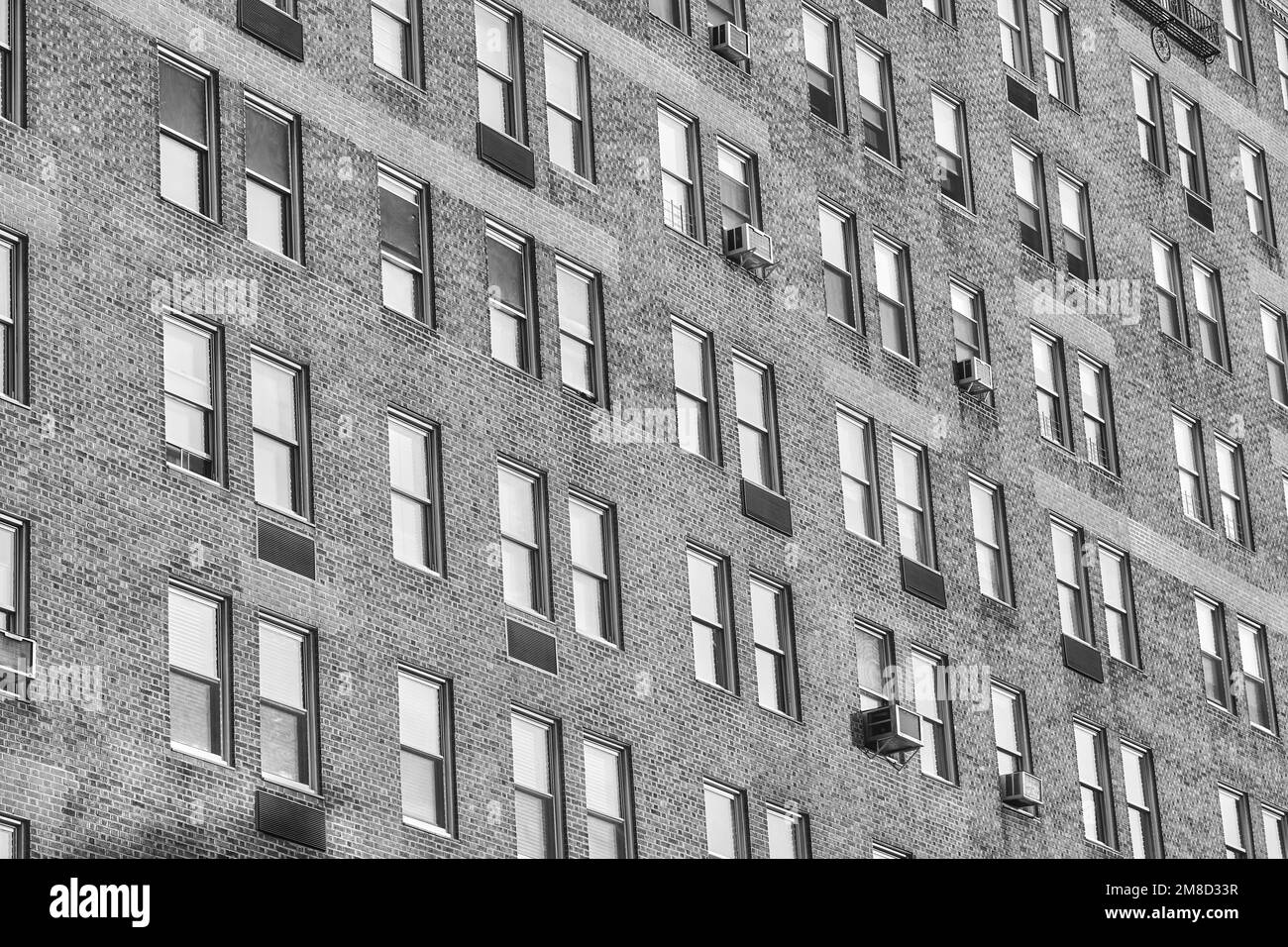 Une photo en noir et blanc d'un ancien bâtiment résidentiel avec façade et fenêtres en briques, New York City, Etats-Unis. Banque D'Images