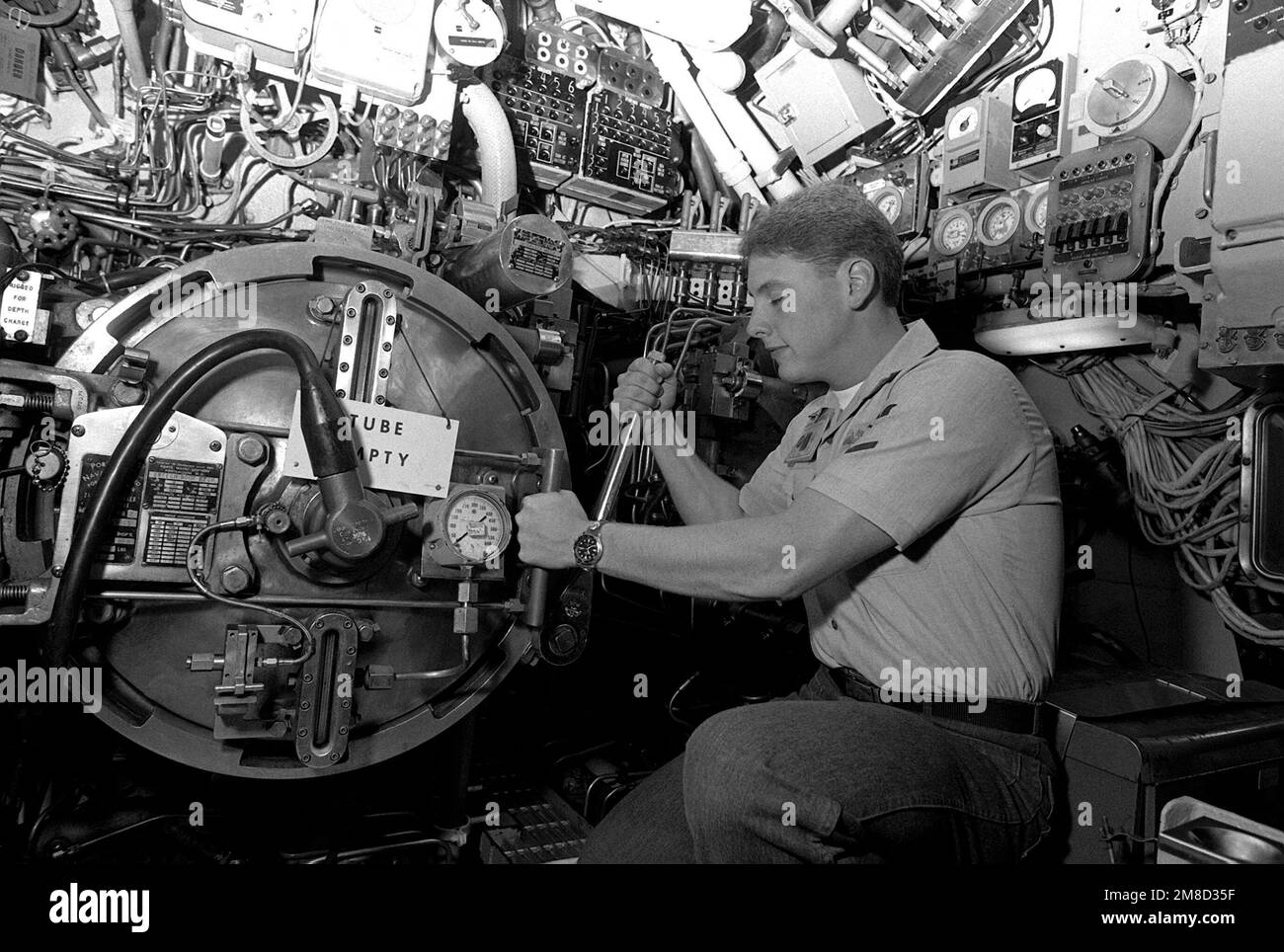 Un petit officier ouvre la porte de brèche d'une torpille à bord du sous-marin d'attaque USS BLUEBACK (SS-581). Le BLUEBACK, un sous-marin diesel-électrique, doit être mis hors service après plus de 30 ans de service actif. Base: Naval Air Station, San Diego État: Californie (CA) pays: Etats-Unis d'Amérique (USA) Banque D'Images